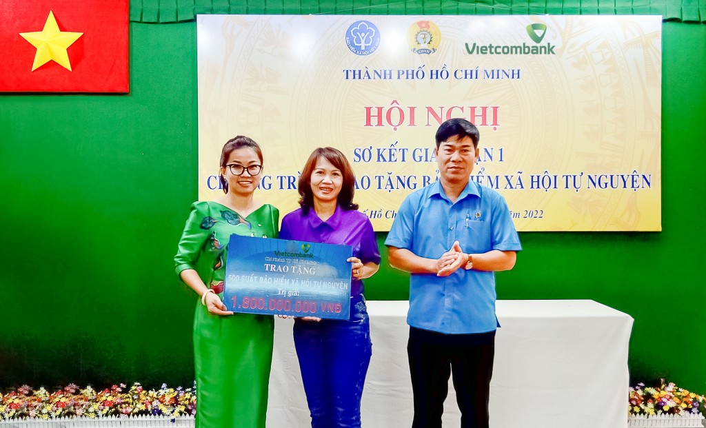 Bà Lê Thị Hòa Bình - Phó Giám đốc Vietcombank TP.HCM (bên trái) trao bảng tượng trưng tái tục BHXH trị giá 1,8 tỷ đồng cho đại diện đoàn viên các nghiệp đoàn nhận BHXH năm 2021