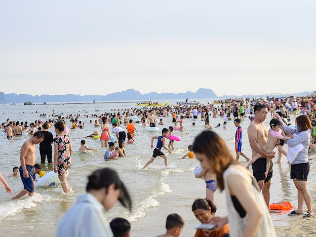Trong hai ngày 17-19/7, bãi biển Hạ Long (khu du lịch Bãi Cháy, thành phố Hạ Long, tỉnh Quảng Ninh) chật kín du khách. Đây là một trong số ít bãi biển thuận tiện để nghỉ mát ở miền Bắc nên luôn thu hút rất đông người dân đổ về vui chơi.