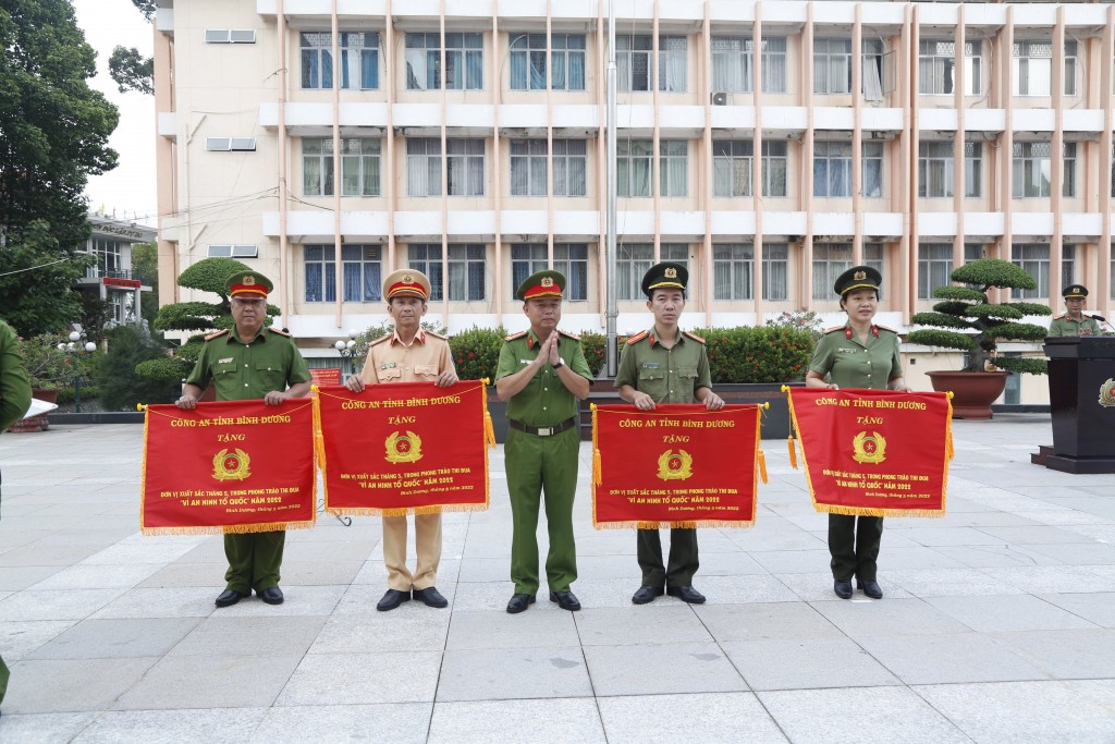 Đại tá Trần Văn Chính, PGĐ Công an tỉnh Bình Dương trao cờ thi đua xuất sắc cho các đơn vị có thành tích cao trong thực hiện phong trào thi đua Vì An ninh Tổ quốc nhân buổi Chào cờ hàng tháng