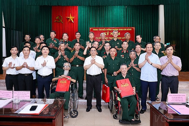 Thủ tướng và đoàn công tác chụp ảnh lưu niệm cùng các thương binh, bệnh binh tại Trung tâm - Ảnh: VGP/Nhật Bắc