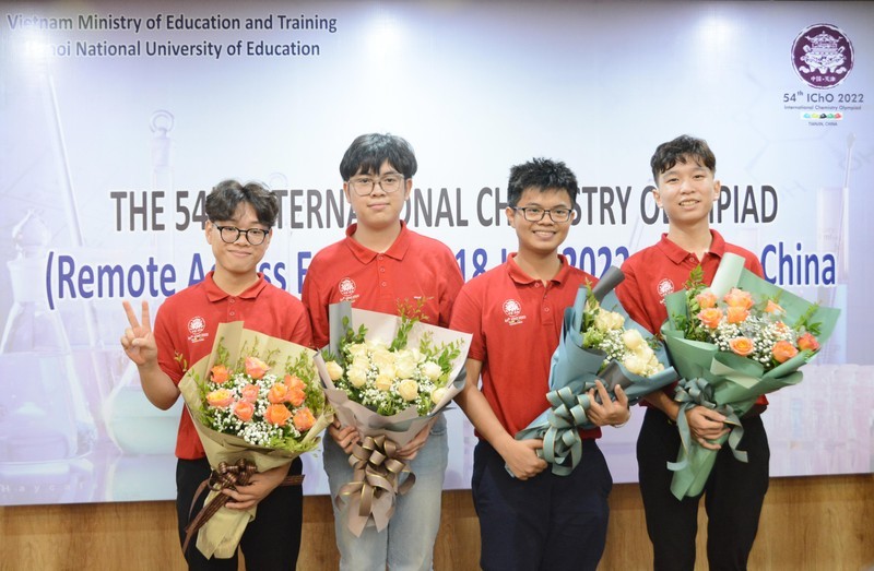 Minh Tuấn (thứ 2 từ trái sang) cùng 3 thành viên đội tuyển nhận hoa chúc mừng tại Lễ báo cáo kết quả thi của đội tuyển Hóa