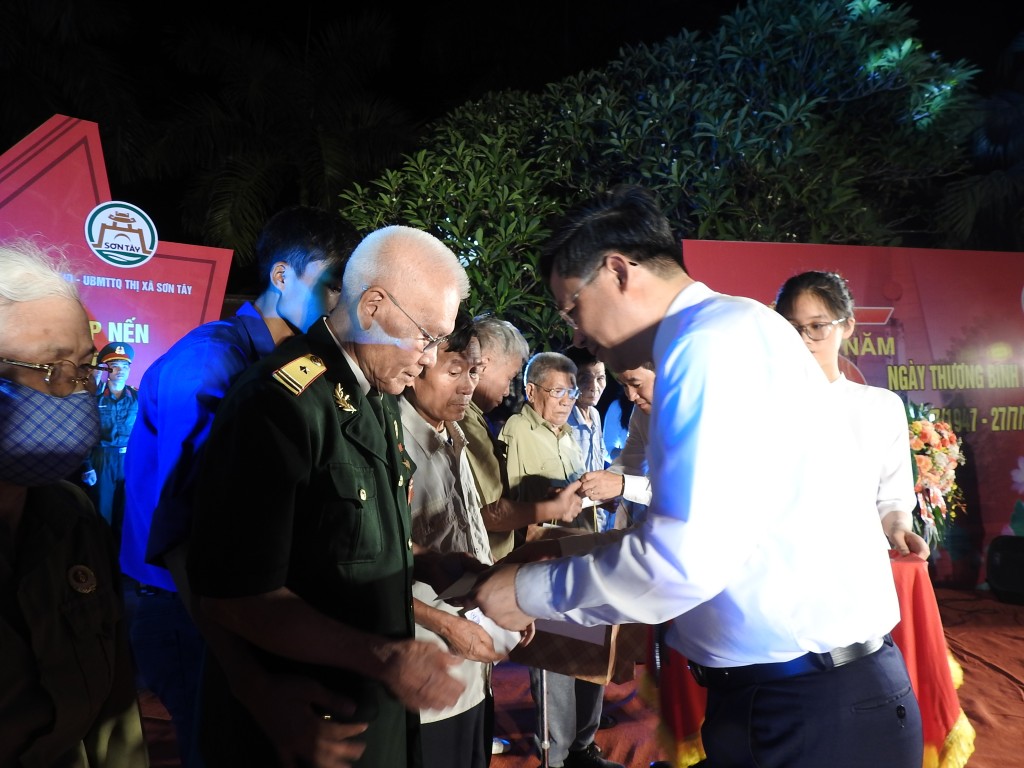 Phó Chủ tịch UBND thành phố Hà Minh Hải trao quà  Anh hùng Lực lượng vũ trang nhân dân Phùng Văn Lừu; đại diện các gia đình chính sách, thân nhân liệt sĩ đang sinh sống trên địa bàn thị xã