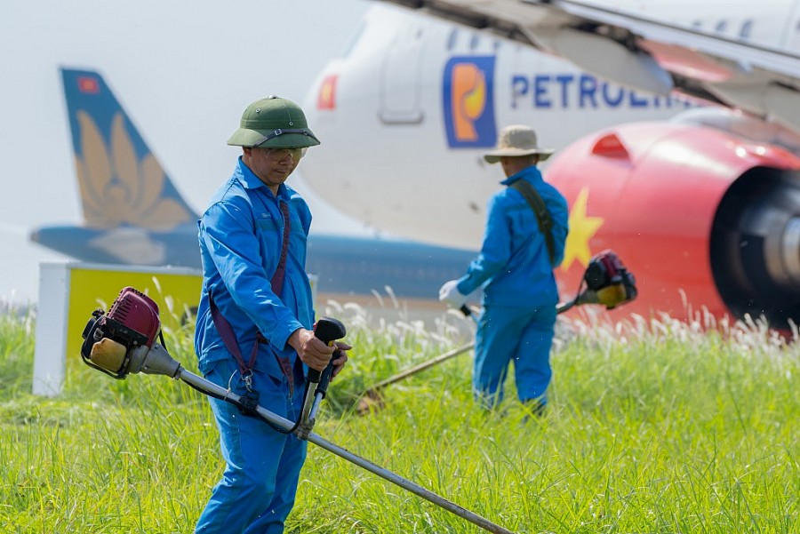 Lực lượng người lao động Đội môi trường khu bay chạy đua với thời tiết để cắt cỏ, vệ sinh môi trường đảm bảo an toàn bay