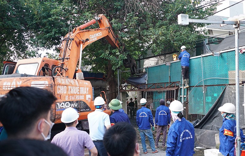 Lực lượng chức năng huy động máy xúc hỗ trợ phá dỡ các công trình tạm để giải phóng mặt bằng