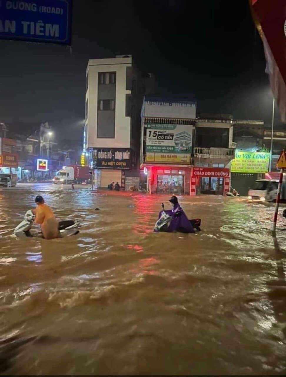 Tại khu vực Hà Khẩu, nước ngập đến đầu gối, các phương tiện xe máy bị chết máy giữa đường, người dân dắt bộ để di chuyển qua khu vực này. 