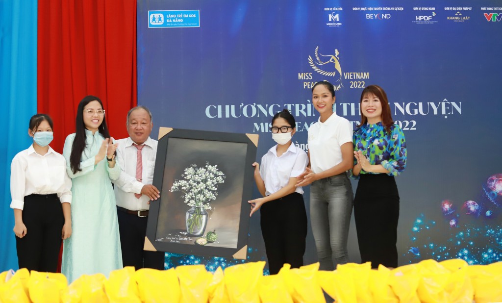 Ban tổ chức Miss Peace Vietnam, Hoa hậu đại sứ H’Hen Niê nhận tranh của các em trong làng SOS Đà Nẵng tặng để đấu giá trong đêm Gala tri ân