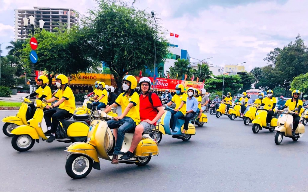 Du khách nước ngoài thích thú trải nghiệm đi xe vespa khám phá TP Hồ Chí Minh