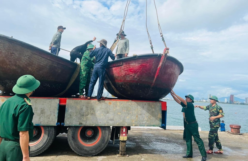 Bộ đội Biên phòng quận Sơn Trà hỗ trợ ngư dân đưa thuyền thúng lên bờ để tránh bão số 4 (Ảnh BĐBP cung cấp)