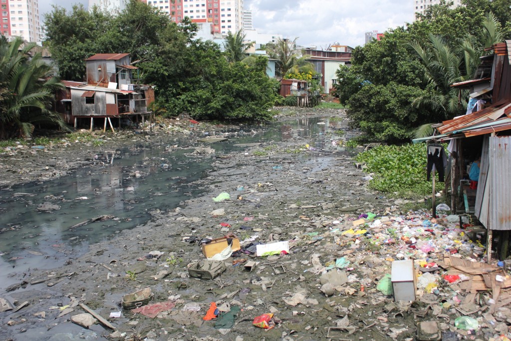 Rác thải nhựa trộn lẫn bùn đất chất đống ngay dưới nhà dân, cảnh tượng không hiếm dọc bờ kênh Xuyên Tâm