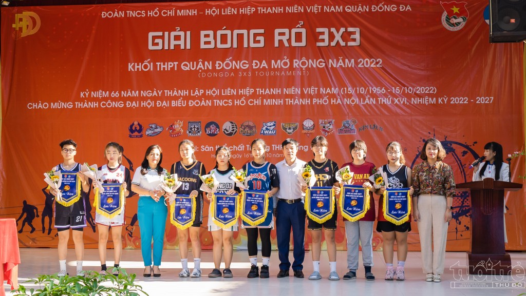 Đồng chí Nguyễn Trường An và đồng chí Trần Quang Long trao cờ lưu niệm tới 8 đội bóng rổ nữ