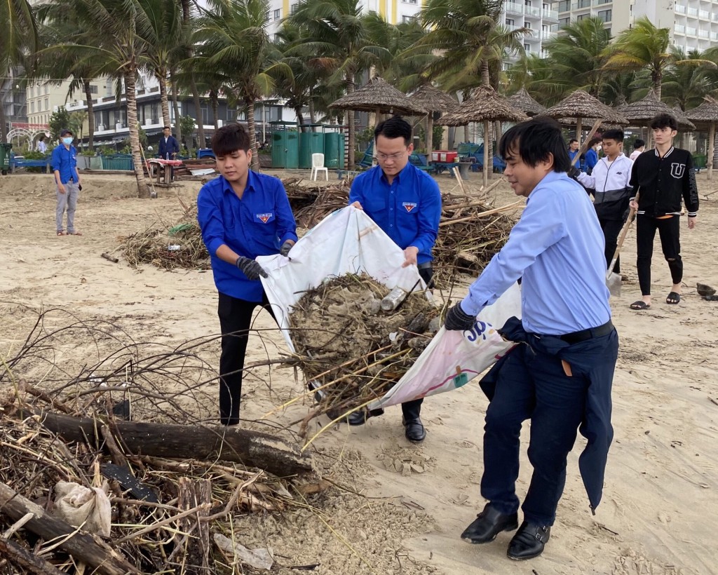 Từ phải qua, ông Tô Mạnh Hùng Giám đốc Sở TN&MT và Bí thư Thành đoàn Đà Nẵng Nguyễn Mạnh Dũng cùng tình nguyện viên tham gia làm sạch bãi biển (Ảnh Đ.Minh)