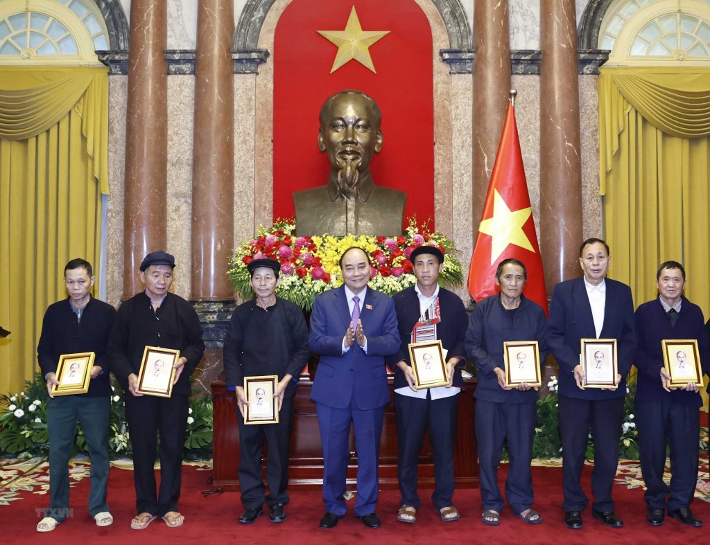 Chủ tịch nước Nguyễn Xuân Phúc tặng chân dung Chủ tịch Hồ Chí Minh cho đại biểu người có uy tín tiêu biểu tỉnh Hà Giang. (Ảnh: Thống Nhất/TTXVN)