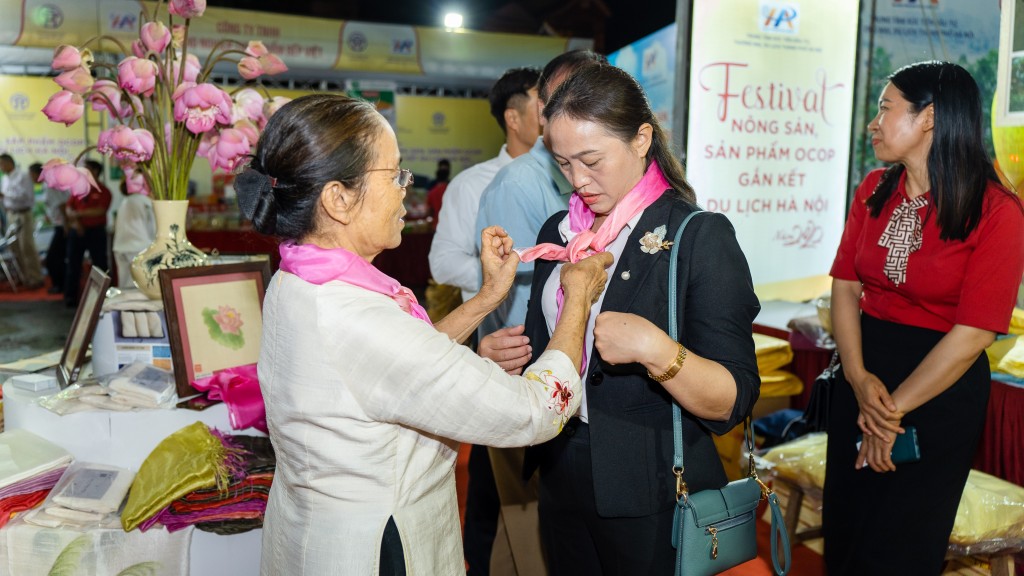 Nghệ nhân ưu tú Phan Thị Thuận giúp khách tham quan trải nghiệm những sản phẩm từ tơ sen được tốt nhất