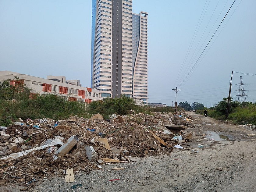 ngay khu vực gầm cầu vượt Yên Nghĩa - đoạn tiếp giáp với phía sau trường Đại học Phenikaa, rác thải xây dựng được chất thành nhiều đống cao