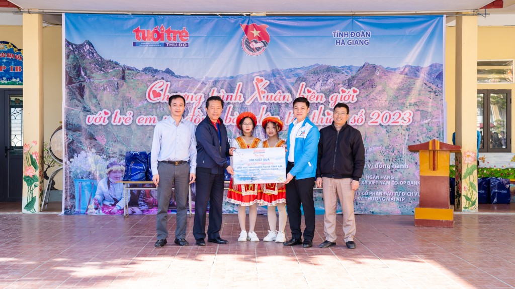 Đồng chí Ngô Vương Tuấn, Phó Tổng biên tập báo Tuổi trẻ Thủ đô và ông Hoàng Tuấn Long, Phó Chủ tịch Công đoàn Ngân hàng Hợp tác xã trao quà cho các em học sinh trường Tiểu học và THCS Tùng Vài