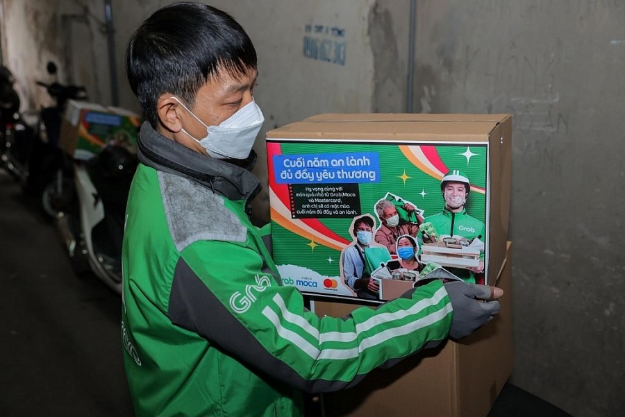 Một tài xế Grab đại diện cho Mastercard và Grab Việt Nam mang những phần quà Tết dành tặng cho các gia đình có hoàn cảnh khó khăn tại Hà Nội