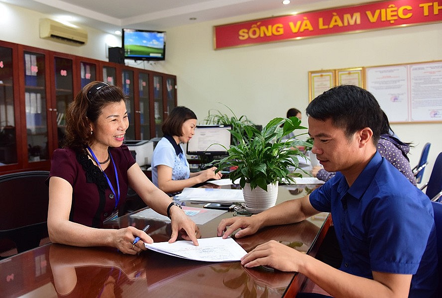Cán bộ bộ phận “một cửa” phường Việt Hưng (quận Long Biên) nhiệt tình hướng dẫn người dân làm thủ tục hành chính