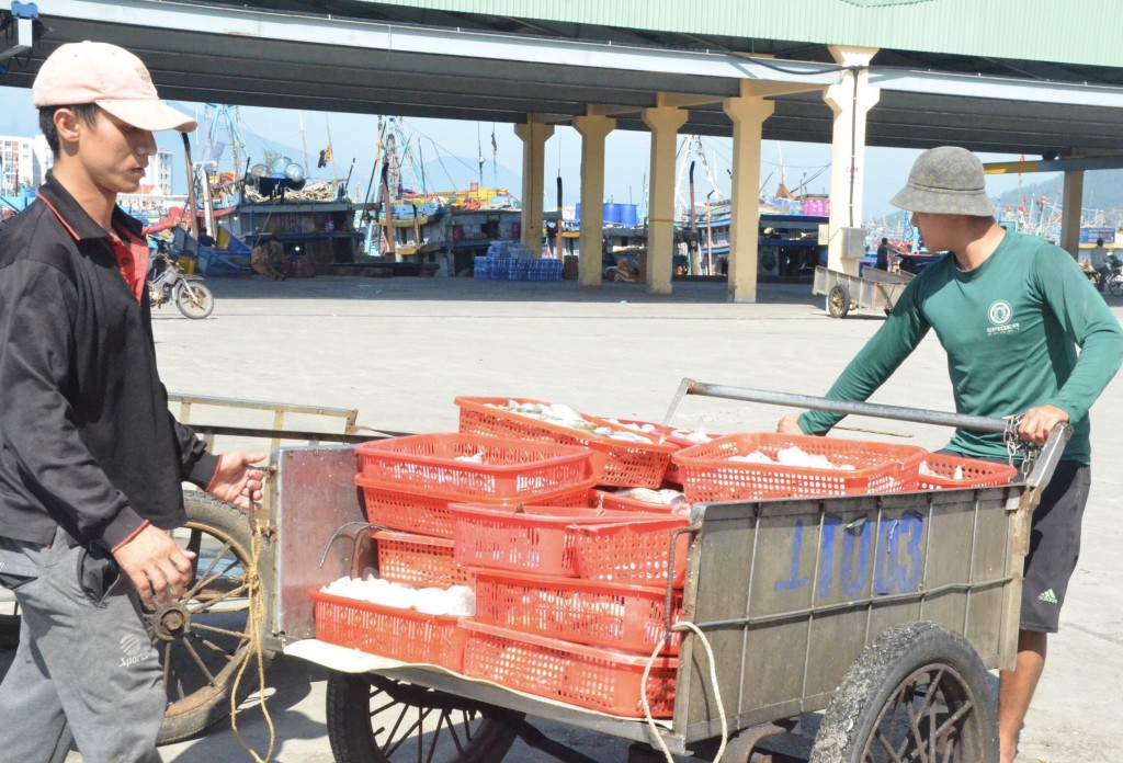 Trên bờ, các tiểu thương chờ để mua được những mẻ hải sản tươi ngon đầu năm (Ảnh Đ.Minh)