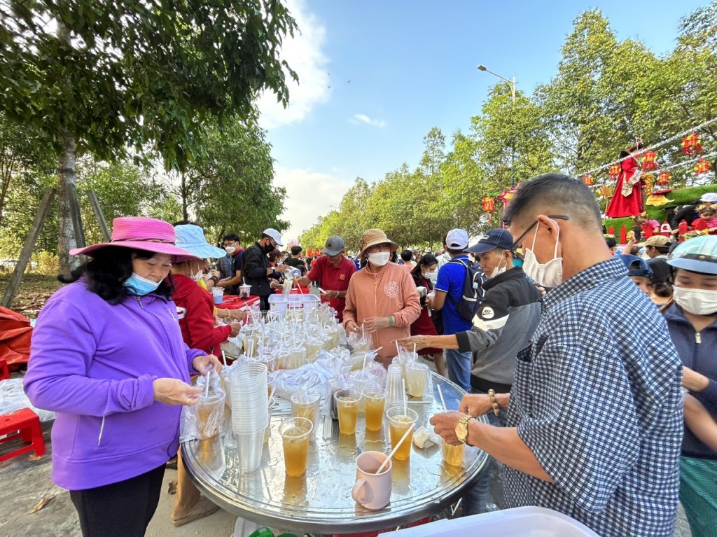 Nhiều người dân tham gia phục vụ nước uống miễn phí cho khách đi xem rước kiệu Bà tại khu vực Thành phố mới Bình Dương v