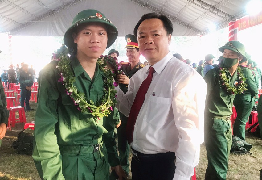 Ông Nguyễn Văn Đông, Ủy viên Thường vụ Tỉnh ủy, Bí thư Thành ủy Thủ Dầu Một, trao hoa, động viên thanh niên trúng tuyển lên đường nhập ngũ
