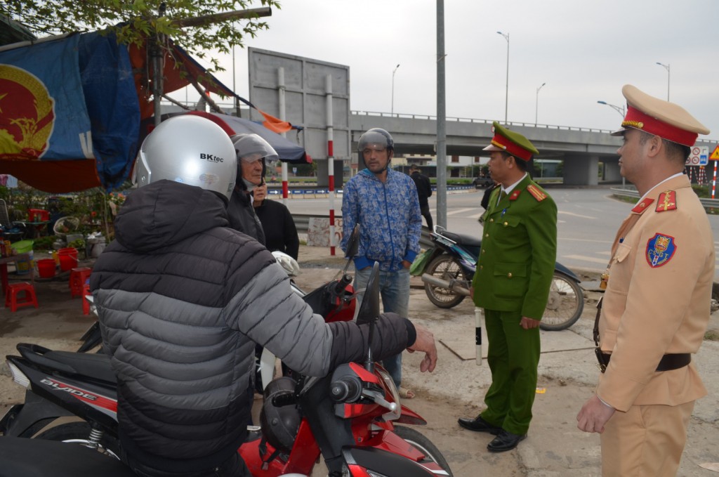 Lực lượng CAGT thị xã Quảng Yên nhắc nhở tài xế xe ôm không được đón khách dưới lòng đường để tránh bị xử phạt không đáng có.