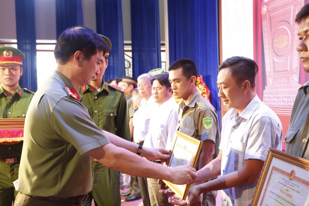 Đại tá Trịnh Ngọc Quyên, Giám đốc Công an tỉnh Bình Dương tặng giấy khen cho các cá nhân có thành tích xuất sắc trong phong trào toàn dân bảo vệ ANTQ. Ảnh: LA