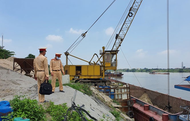 Lực lượng Cảnh sát giao thông đường thủy (Công an thành phố Hà Nội) kiểm tra một bến tập kết vật liệu xây dựng hoạt động không phép ven sông Hồng tại xã Thống Nhất (huyện Thường Tín)