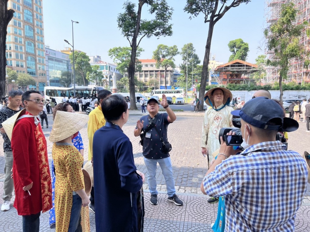 Du khách Trung Quốc chụp ảnh kỉ niệm với chiếc áo dài truyền thống của Việt Nam