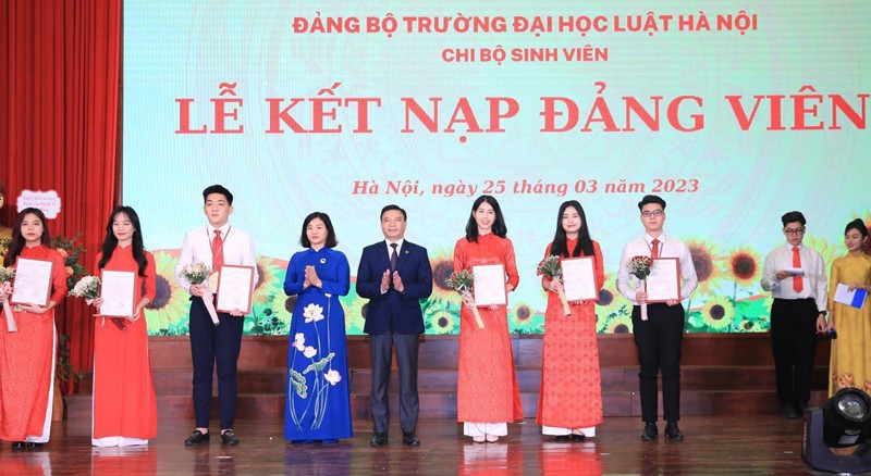 Phó Bí thư Thường trực Thành ủy Hà Nội Nguyễn Thị Tuyến và Chủ tịch Hội đồng Trường Đại học Luật Hà Nội Chu Mạnh Hùng trao Quyết định và tặng hoa chúc mừng các đảng viên.