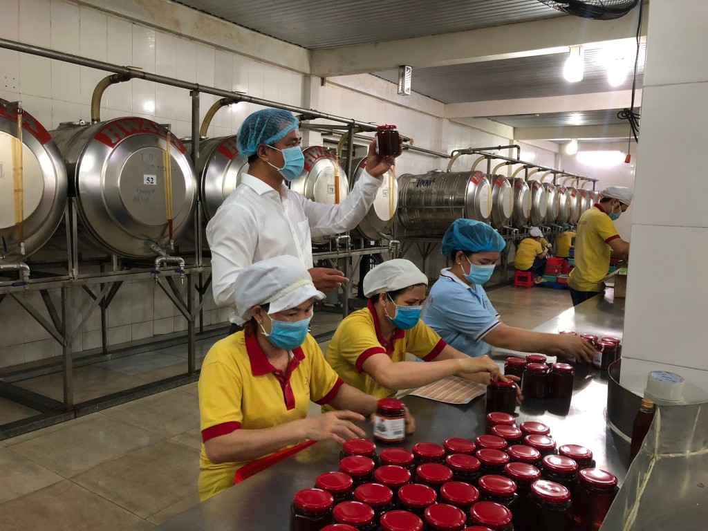 Công nhân đang kiểm tra và đóng chai sản phẩm mật ong Xuân Nguyên