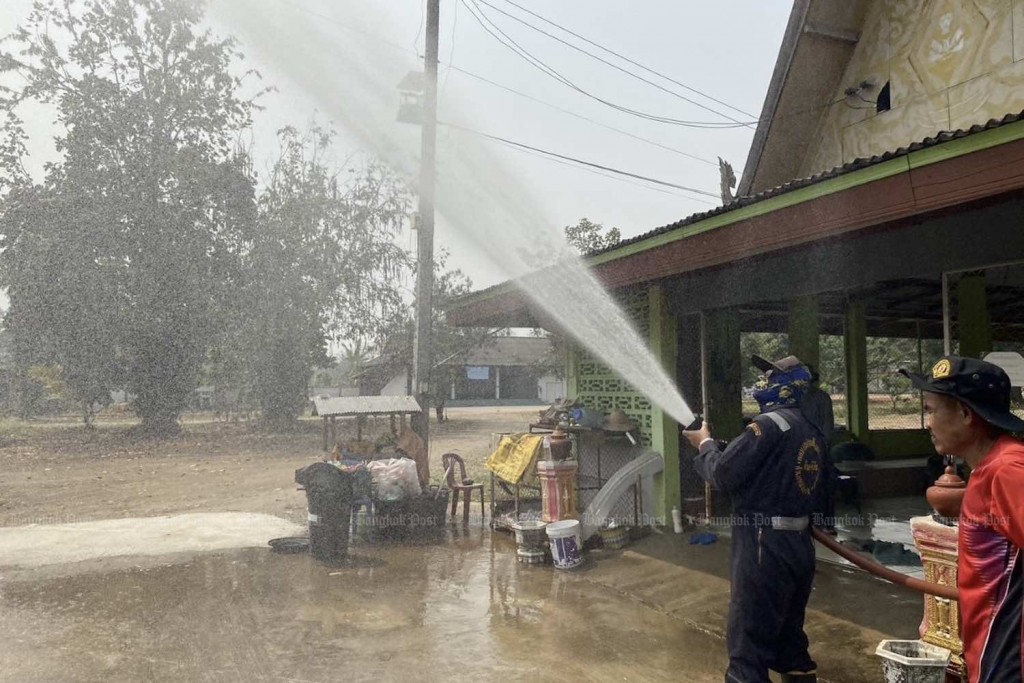 Một nhân viên cứu hộ phun nước lên trời để giảm sương mù ở tỉnh Chiang Mai vào đầu tháng này (Ảnh: Panumet Tanraksa)