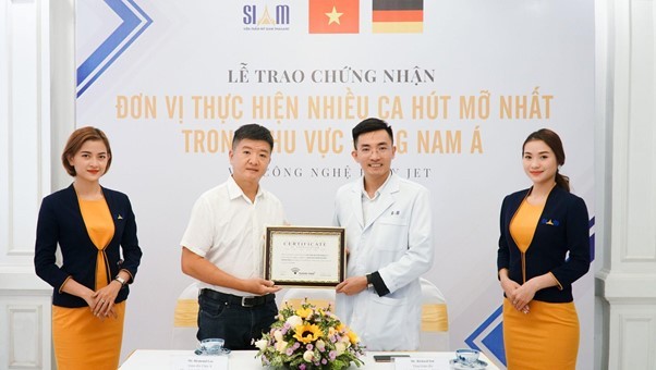 Ông Desmond Loo (Đại diện Human Med khu vực châu Á) trao kỷ niệm chương và chứng nhận đơn vị hút mỡ tia nước số 1 Đông Nam Á cho ông Thái Hoàng Sơn (CEO Viện thẩm mỹ Siam Thailand)