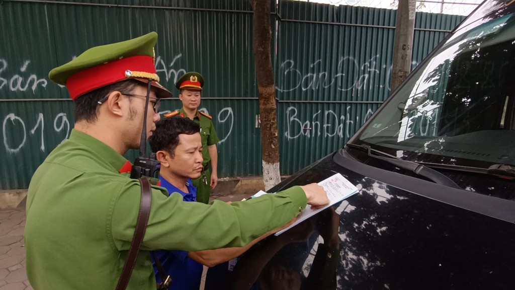 Lực lượng chức năng phường Dịch Vọng lập biên bản xử lý vi phạm hành chính xe chở khách dừng đỗ sai quy định