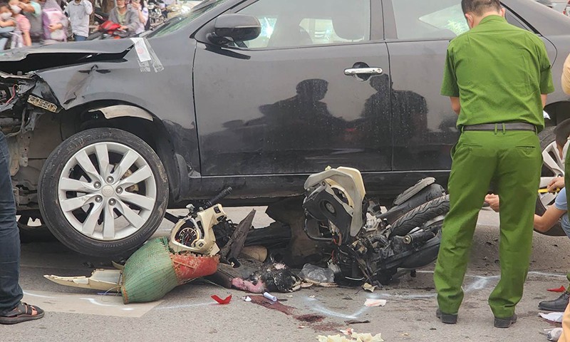 Một chiếc xe máy còn kẹt trong gầm xe ô tô sau tai nạn