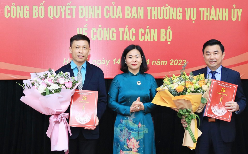 Phó Bí thư Thường trực Thành ủy Hà Nội Nguyễn Thị Tuyến trao Quyết định của Ban Thường vụ Thành ủy và tặng hoa chúc mừng hai đồng chí Nguyễn Minh Đức và Nguyễn Thành Lợi