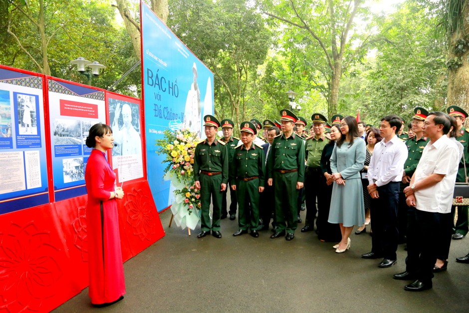 Các đại biểu nghe thuyết minh giới thiệu Triển lãm ảnh