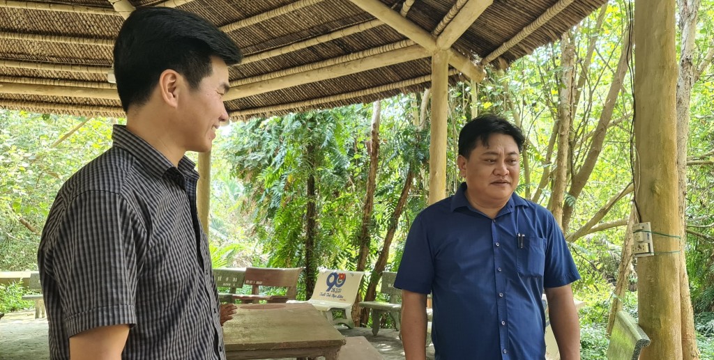 Tác giả (bên trái) trao đổi với Chủ tịch UBND xã Ninh Thạnh Lợi