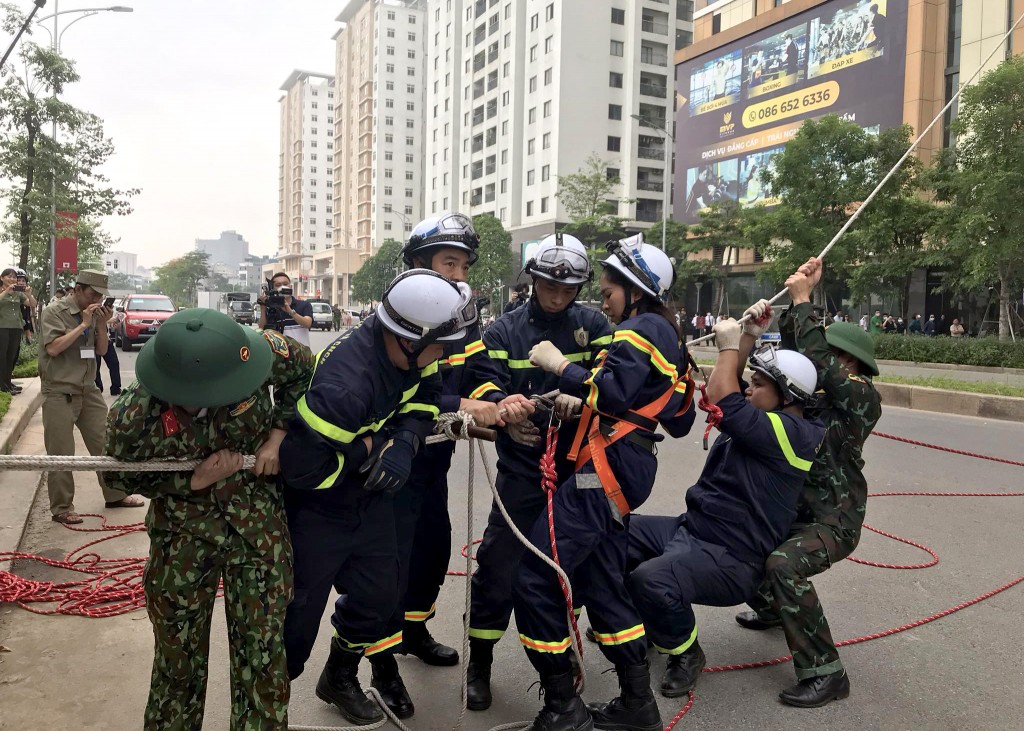 Sau khi cứu người mắc kẹt trên tầng cao, nữ chiến sỹ Cảnh sát PCCC và CNCH đu dây xuống đất an toàn