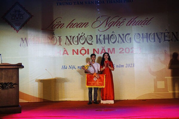 Giám đốc Trung tâm Văn hóa Thành phố Lý Thị Thúy Hạnh – Phó Trưởng Ban Tổ chức Liên hoan trao giải Nhất cho Phường Rối Bình Phú (huyện Thạch Thất)