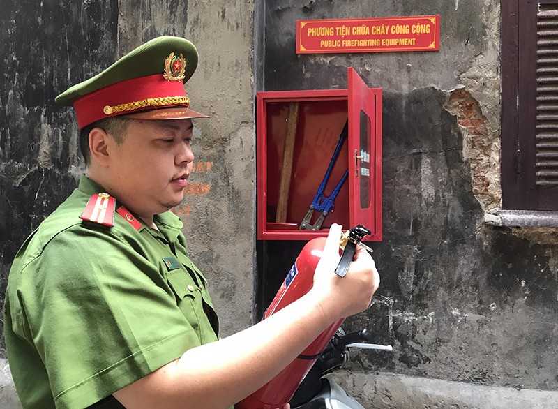 Cán bộ Công an phường Hàng Trống đi tuyên truyền, kiểm tra chuông báo cháy và các phương tiện chữa cháy, cứu nạn được lắp đặt trong các ngõ phố đã thành lập Tổ liên gia an toàn PCCC