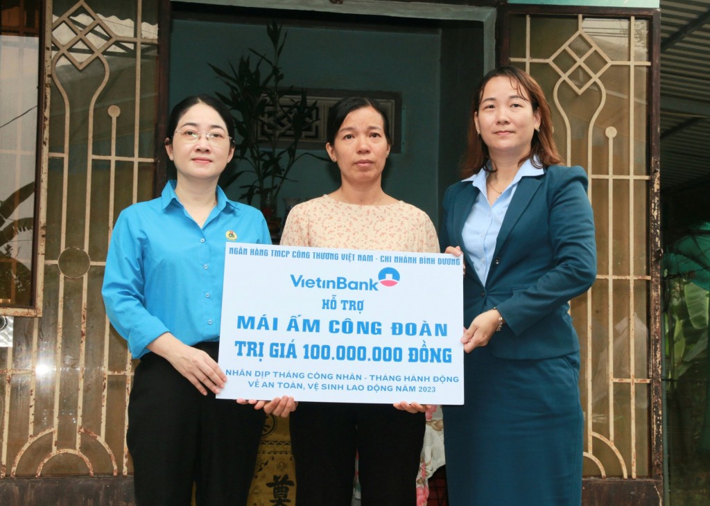 Chủ tịch LĐLĐ tỉnh Nguyễn Kim Loan và đại diện Ngân hàng Vietinbank Bình Dương trao tiền hỗ trợ 100 triệu đồng 