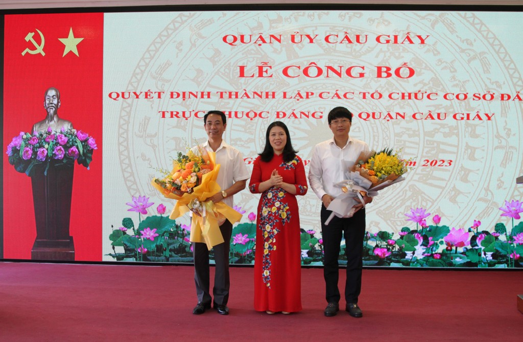 Đồng chí Trần Thị Phương Hoa, Thành uỷ viên, Bí thư Thành uỷ trao quyết định giải thể và tặng hoa nguyên Bí thư Đảng uỷ Cơ quan Dân – Đảng và Đảng uỷ cơ quan UBND quận.