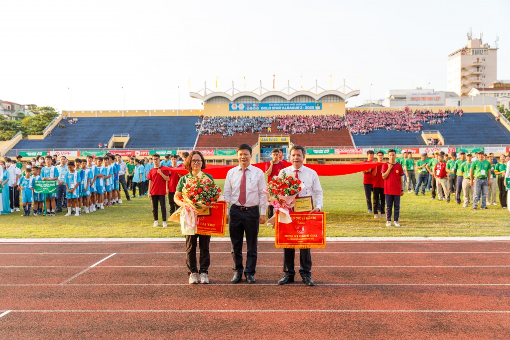 Ông Nguyễn Thanh Đề, Vụ trưởng Vụ Giáo dục thể chất, Bộ Giáo dục và Đào tạo tặng cờ lưu niệm cho đơn vị đăng cai và đơn vị tài trợ_