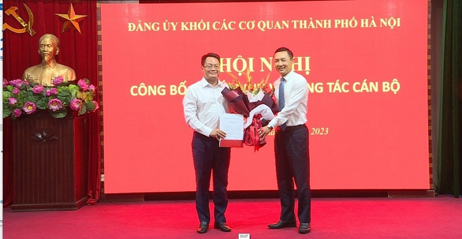 Bí thư Đảng ủy Khối các cơ quan thành phố Hà Nội Doãn Trung Tuấn trao quyết định và tặng hoa chúc mừng đồng chí Nguyễn Việt Hùng