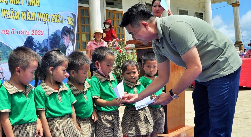 Nhà báo Đặng Trung Kiên - Chủ nhiệm CLB Nhà báo xứ Nghệ tại TP Hồ Chí Minh trao quà cho các em học sinh trong chuyến thiện nguyện trở về quê nhà