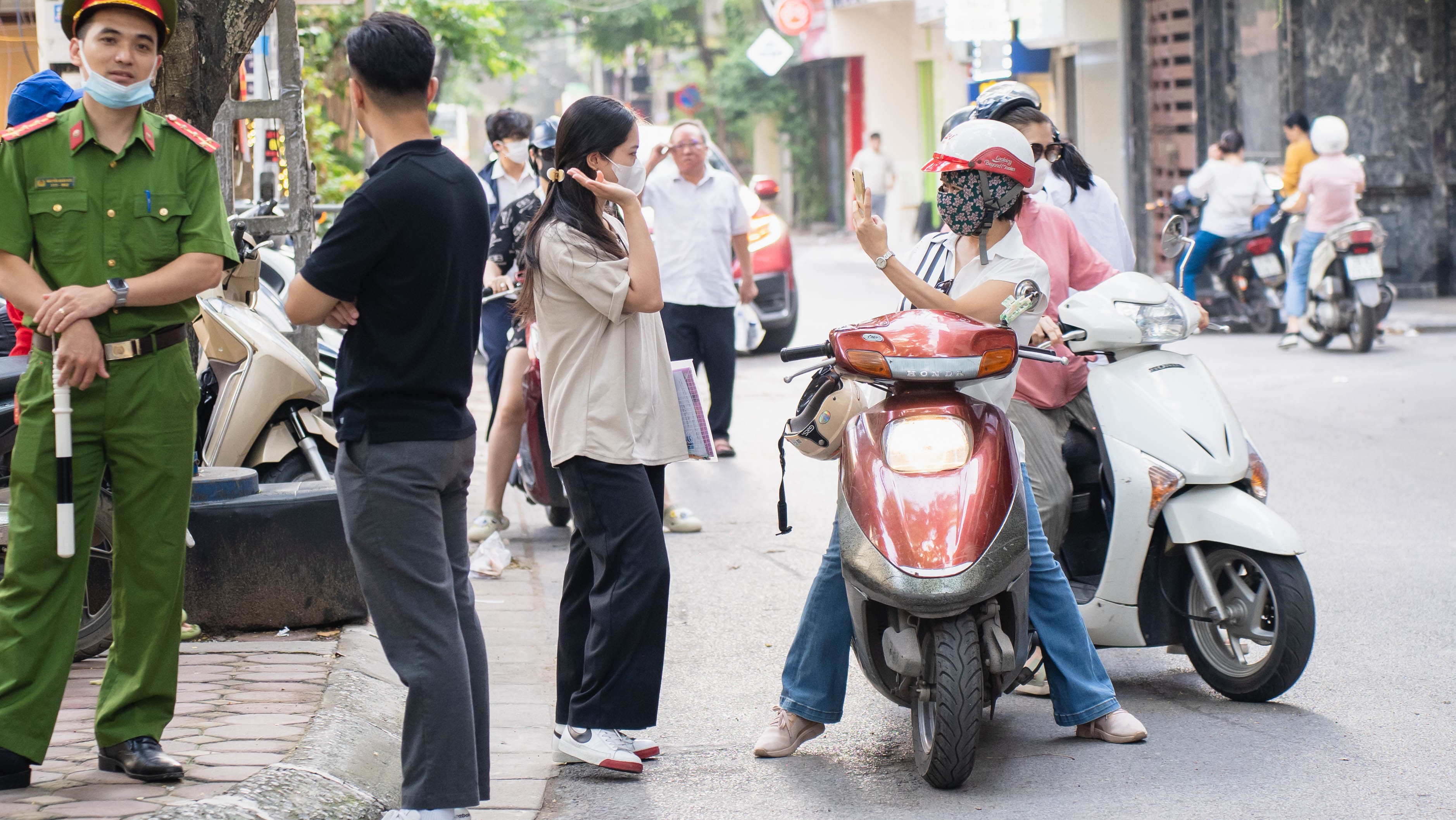 Một phụ huynh tranh thủ chụp hình cho con gái phía bên ngoài điểm thi