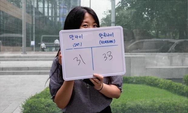 Kim Jin-sil tạo dáng với tấm bảng trắng ghi tuổi quốc tế của cô là 31 và tuổi Hàn Quốc là 33 (Ảnh: Getty0