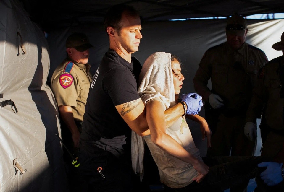  một nhân viên y tế, đang khiêng một người phụ nữ bị kiệt sức vì nắng nóng lên cáng tại thành phố Eagle Pass của bang Texas vào hôm 26/6. Ảnh: Reuters.