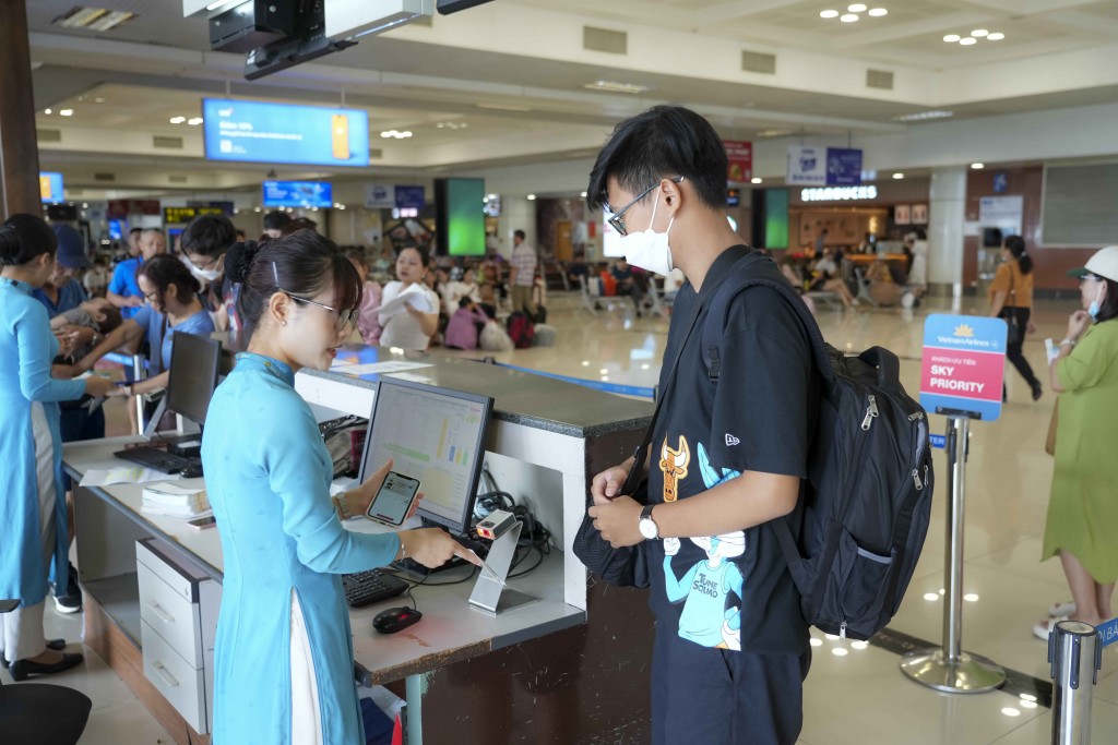 Một hành khách sử dụng tài khoản VNeID mức độ 2 để vào cửa lên máy bay