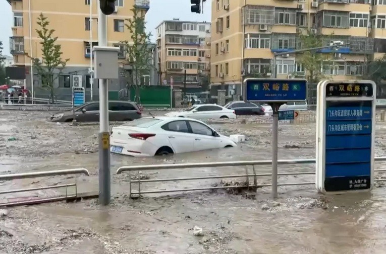 Ô tô ngập trong nước trên đường phố Bắc Kinh do ảnh hưởng của bão Doksuri (Ảnh: Reuters)